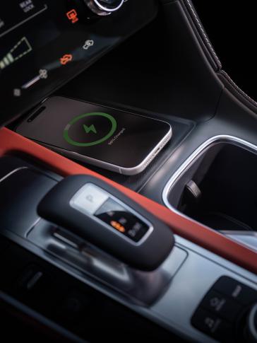 Close up of the gear shift and mobile device charger area inside the 2027 INFINITI QX65.