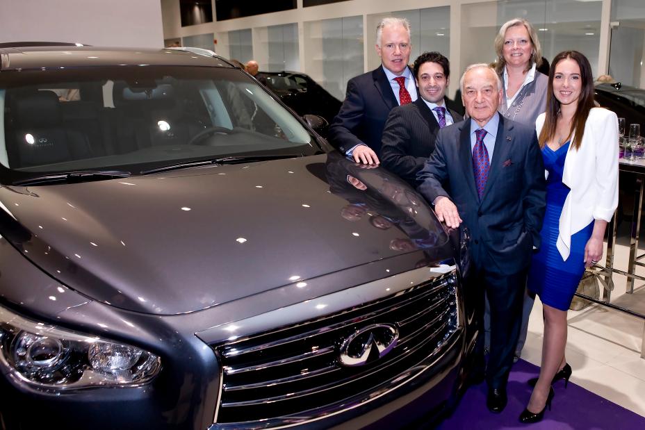 5 individuals posing beside a silver INFINITI for a photo