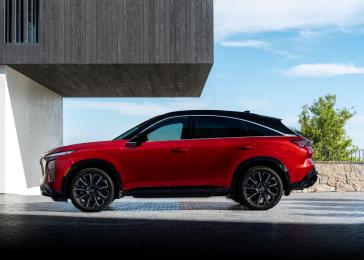 Left profile view of the 2027 INFINITI QX65 parked near a modern building.