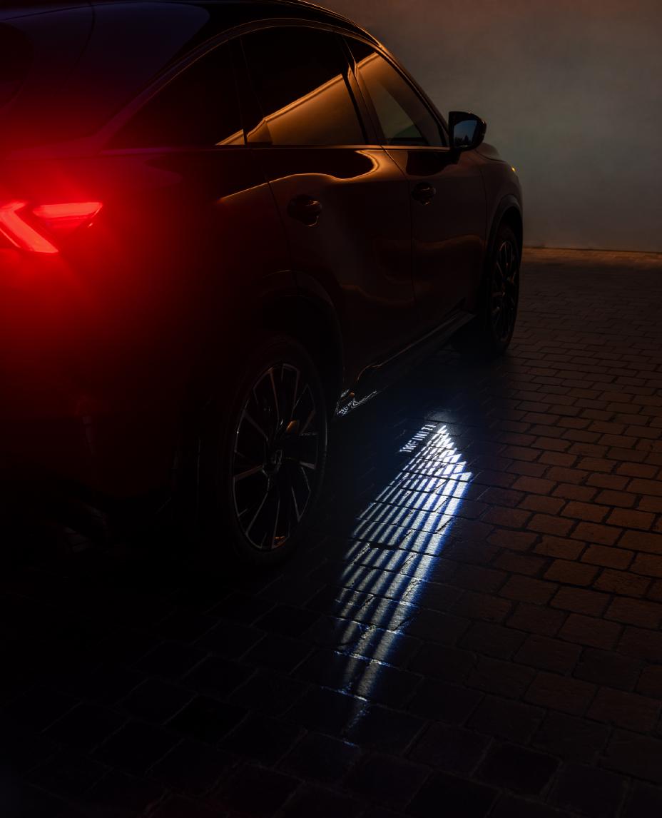 Close up of the INFINITI lighting sequence from the 2027 INFINITI QX65 displayed on the ground at night.