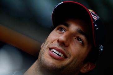 Image of INFINITI driver looking up while smiling and wearing a baseball cap