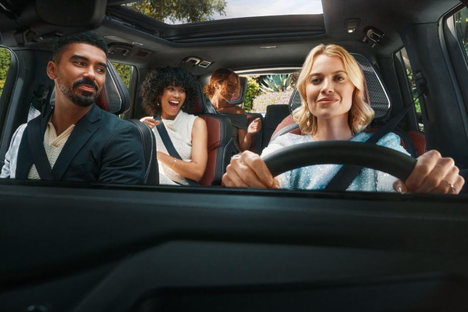 Grupo de amigos viajando felices y relajados en el nuevo NFINITI QX80 Autograph, representando la tranquilidad y respaldo que ofrece el programa INFINITI Protect.