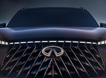 Close up front view of the grill on the QX65 Monograph, the headlights and emblem of illuminated.