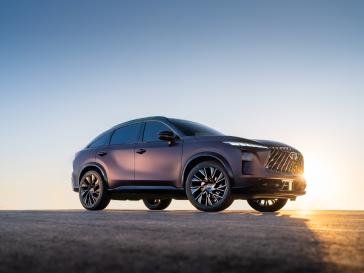 Vue trois quarts avant droite du QX65 Monograph, avec les rayons du soleil traversant le côté de la face avant.